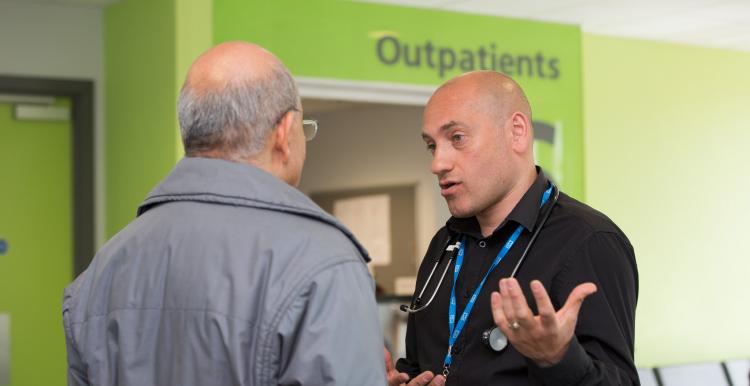 Two men talking in a hospital reception