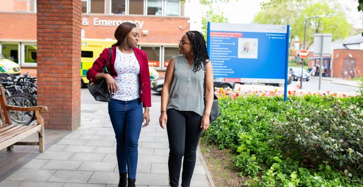 Two females walking outside an accident and emergency department