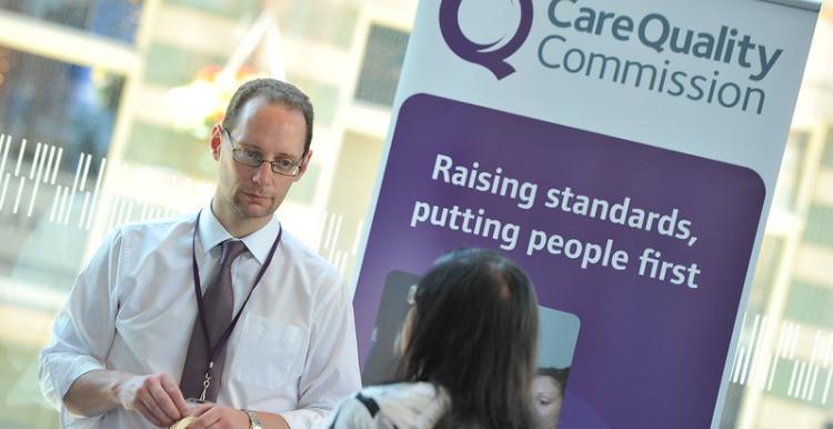 A man standing in front of a CQC sign