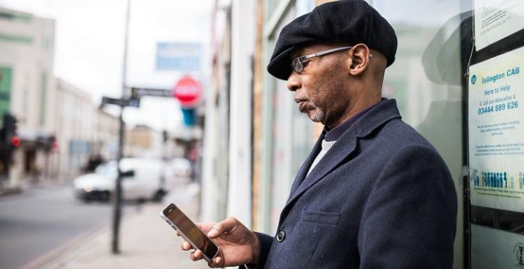 A man standing outside looking at his phone