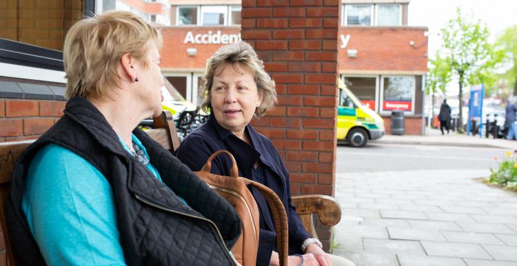 Two Women Sitting Outside Hospital