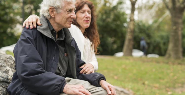 Elderly person sitting on a bench with a friend