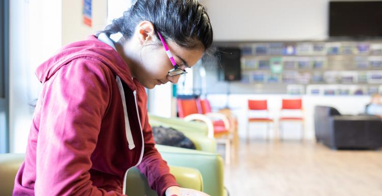 Young person using phone in waiting room