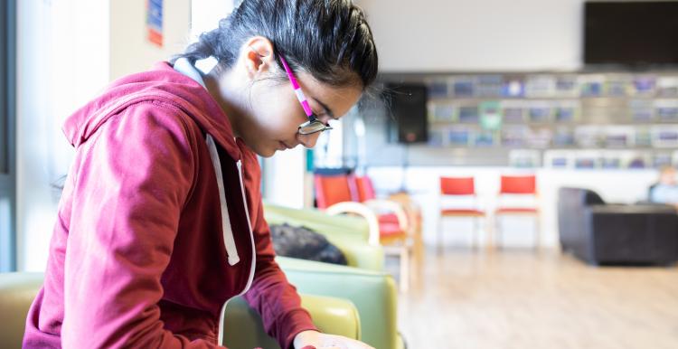 young female sitting down looking at phone