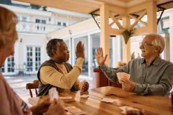 Elderly men high fiving each other.