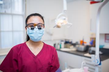 Surgeon wearing a mask in a surgical suite, facing the camera