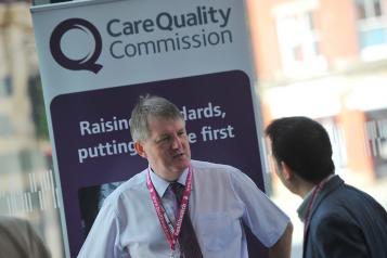 A man standing in front of a CQC sign