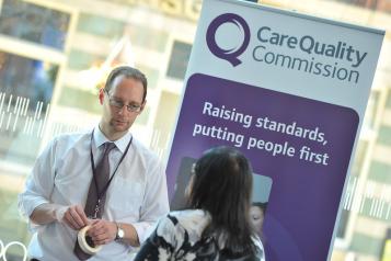 A man standing in front of a CQC sign