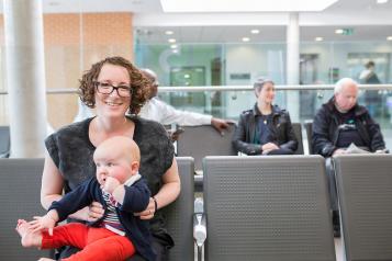 A mother and baby waiting in a waiting room