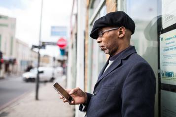 A man standing outside looking at his phone