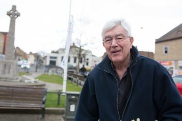 Elderly man with glasses standing outside