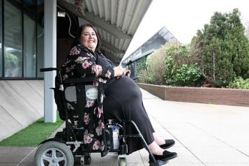 A lady in a wheelchair sitting outside