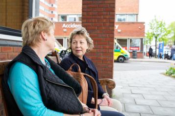 Two Women Sitting Outside Hospital