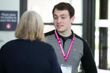 A young man talking to an older lady