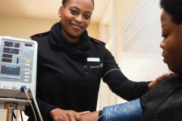 A nurse checking someone's blood pressure