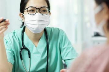 female doctor wearing mask seeing patient