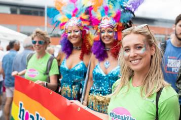 Four women standing in front of a sign at a festival 2