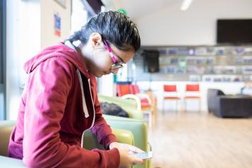 Young person using phone in waiting room