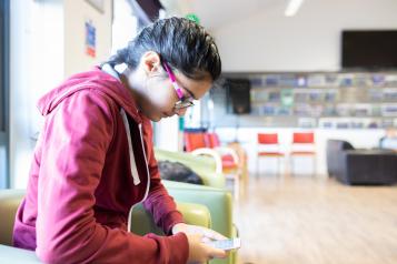 young female sitting down looking at phone