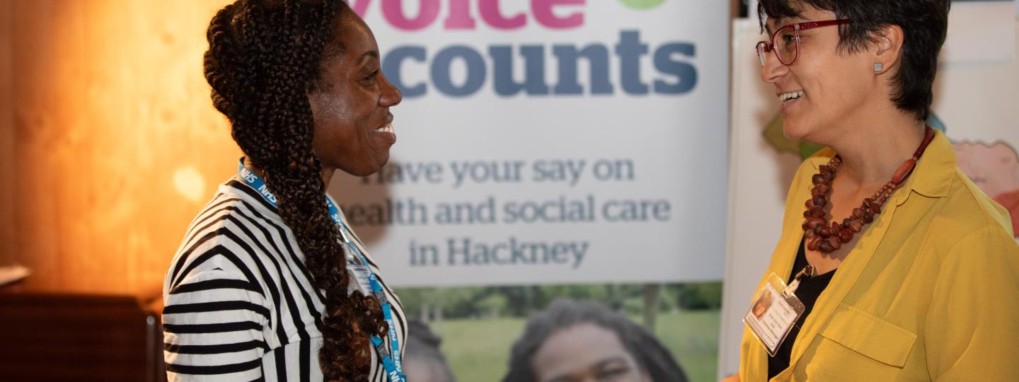 Healthwatch Engagement, two women discussing public health services at networking event. 